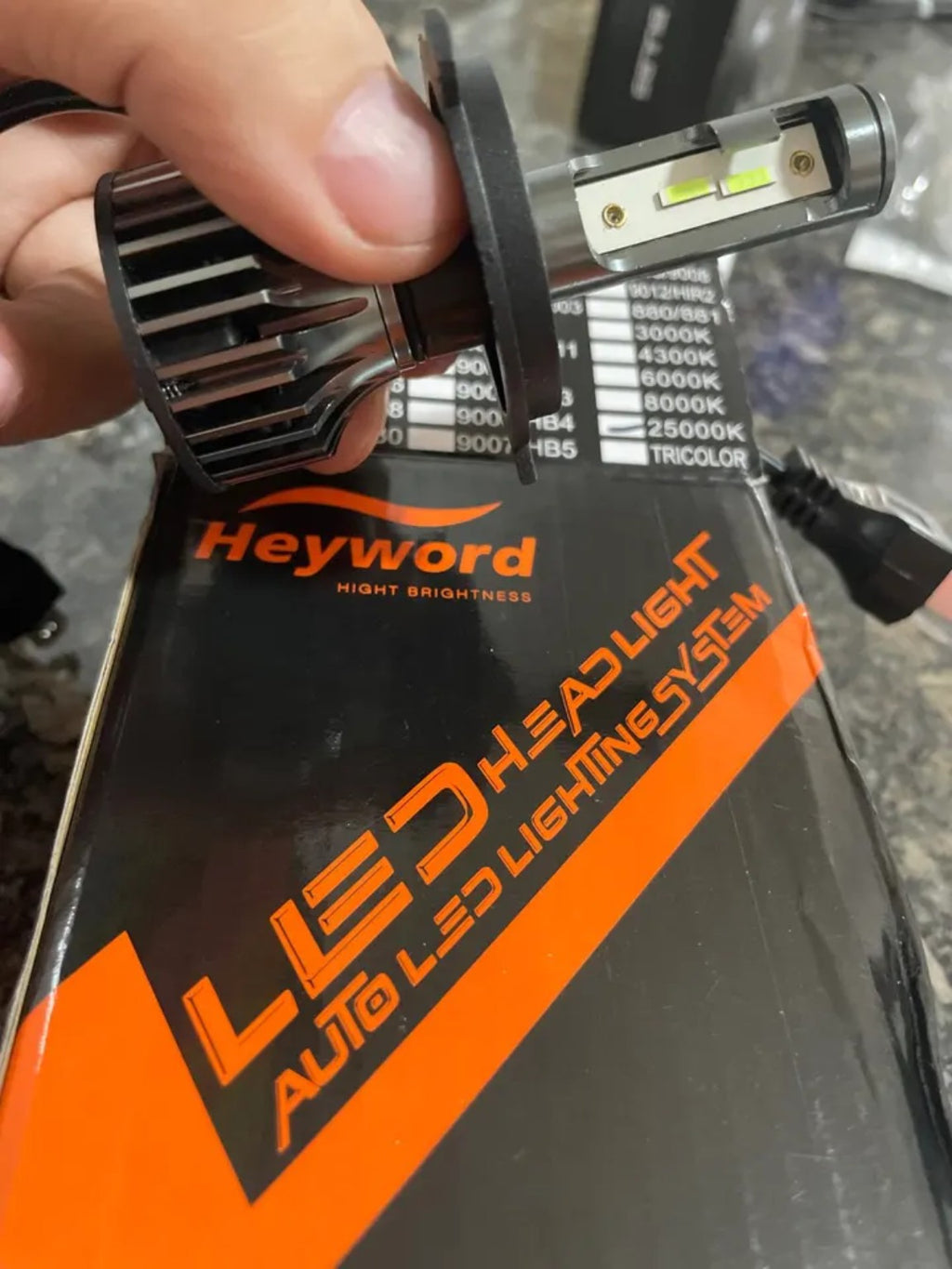 RivoMoto LED headlight bulb close-up with Heyword packaging
