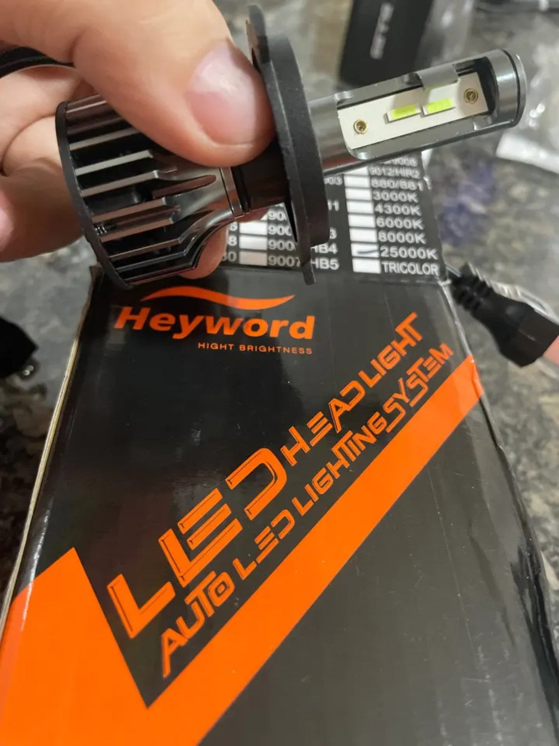 RivoMoto LED headlight bulb close-up with Heyword packaging